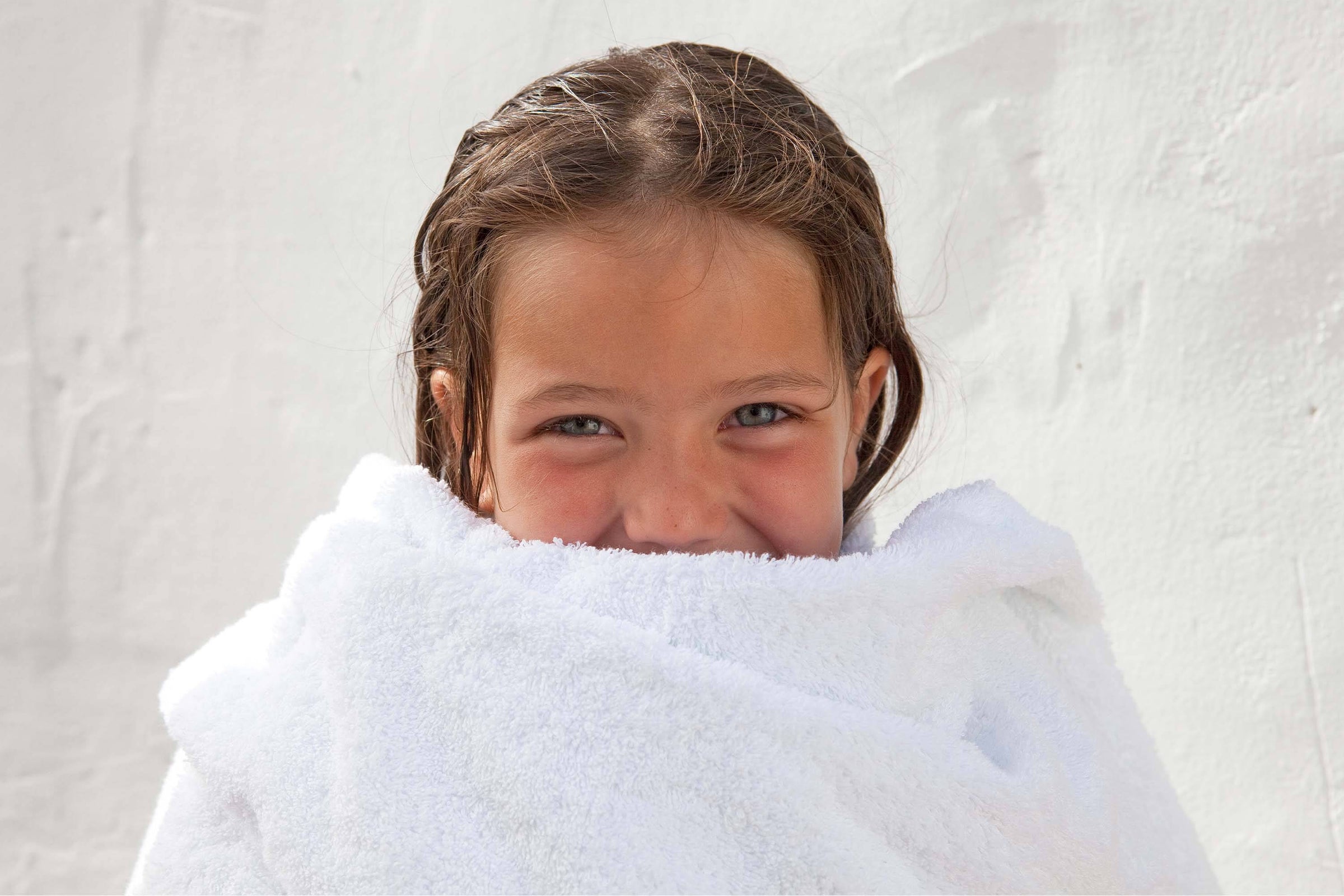 Little girl wrapped in white cotton towel 